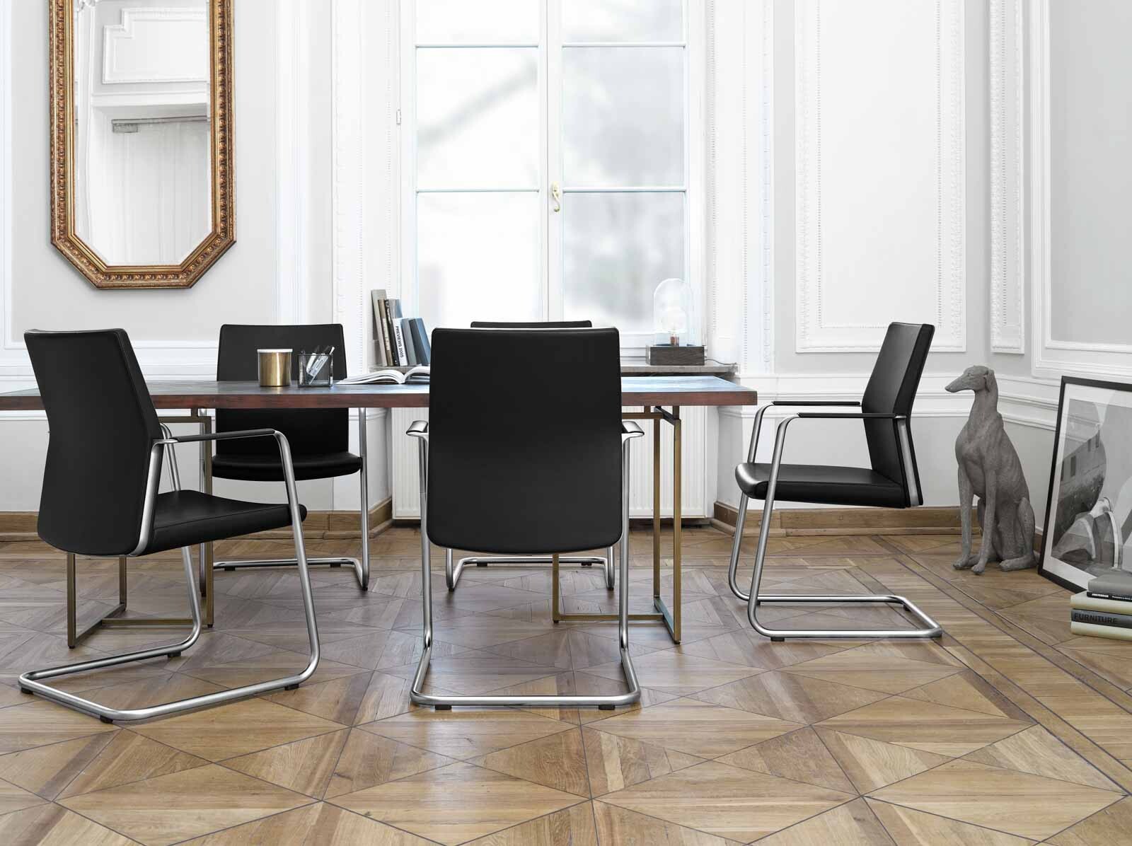 Bild eines Konferenzraumes mit hochwertigen Konferenzstühlen in schwarzer, schlichter Optik. 